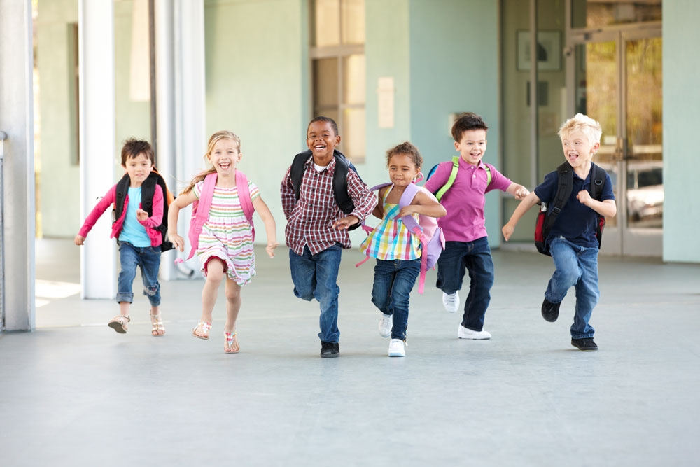 children with back packs run with big smiles