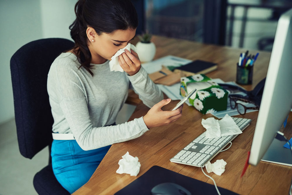 female employee at desk with tissues