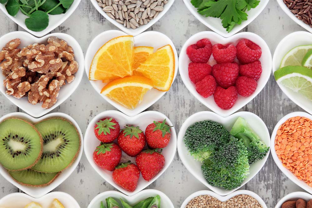 A colorful assortment of fruits and veggies arranged in heart-shaped bowls, showcasing healthy eating in a fun way.