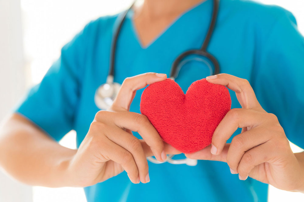 Nurse holding a plush heart 