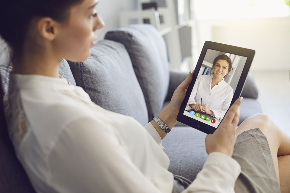 woman talks with counselor on tablet