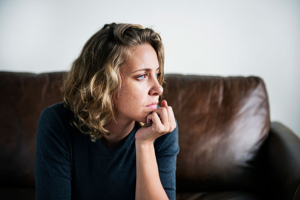 Woman looks out of window sadly