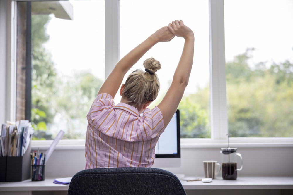 woman stretching at desk