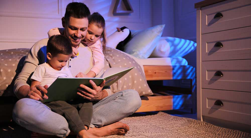 father reading to two kids