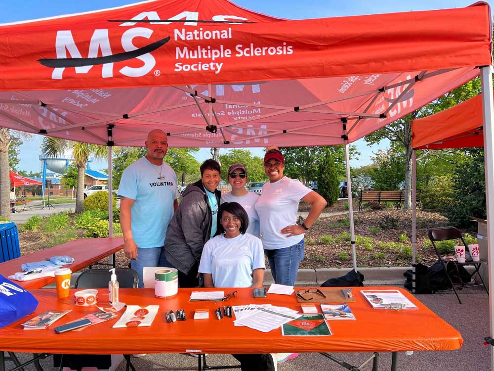 group of employees standing behind volunteer table outside