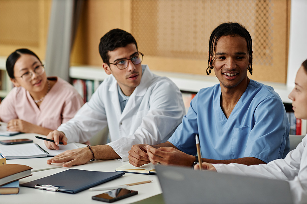 A group of doctors engaged in discussion while seated around a table, showcasing collaboration and teamwork in healthcare.
